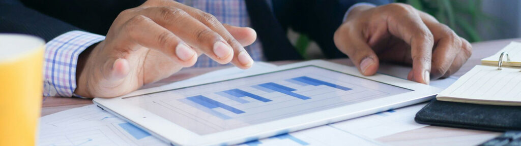Person's hand over a tablet showing a graph