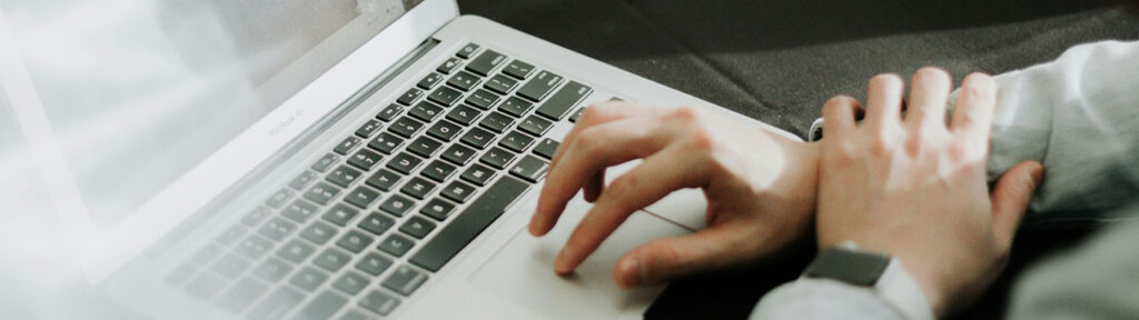 Person's hand on a lap top